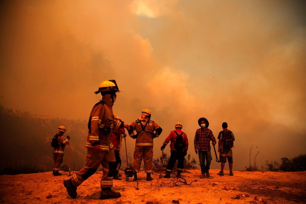 Los bomberos trabajan en la zona de un incendio forestal en las colinas de la comuna de Quilpe, región de Valparaíso, Chile, el 3 de febrero de 2024. La región de Valparaoso y Viña del Mar, en el centro de Chile, se despertó el sábado con un toque de queda parcial para permitir el movimiento de evacuados y traslado de equipos de emergencia en medio de una serie de incendios sin precedentes, informaron las autoridades. (Foto de JAVIER TORRES/AFP vía Getty Images)