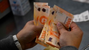 Un hombre cuenta mil billetes de pesos argentinos en Buenos Aires el 11 de septiembre de 2023. (Foto de LUIS ROBAYO/AFP vía Getty Images)