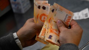 Un hombre cuenta mil billetes de pesos argentinos en Buenos Aires el 11 de septiembre de 2023. (Foto de LUIS ROBAYO/AFP vía Getty Images)