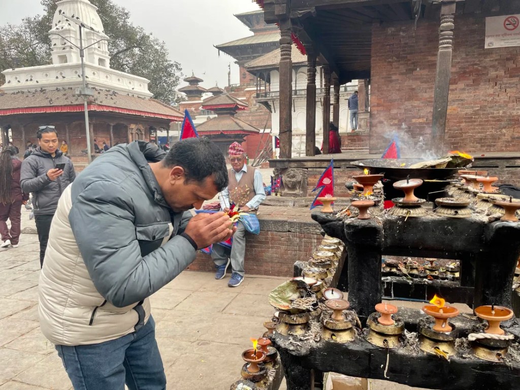 Ramchandra Khadka reza frente a un templo en Katmandú por sus camaradas que luchan por Rusia. (Foto: CNN).
