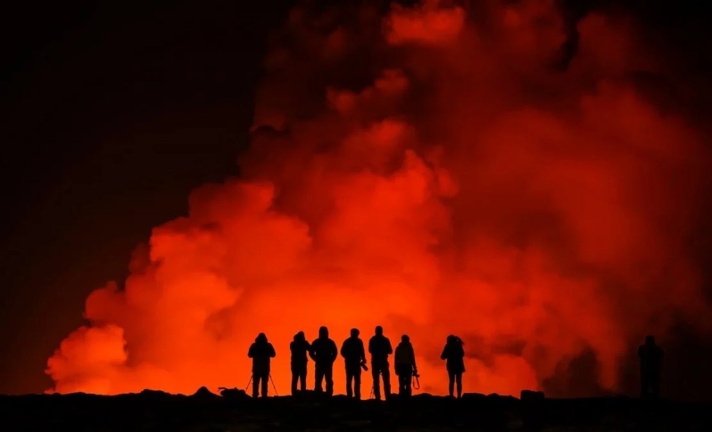 Un grupo de personas observa la erupción. (Foto: Marco Di Marco/AP).