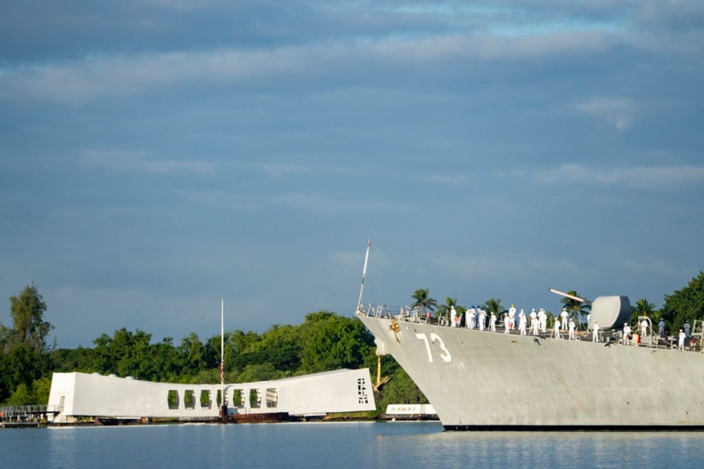 Sailors aboard the USS Decatur pay respects as they pass the USS Arizona Memorial and the sunken battleship USS Arizona during the 82nd Pearl Harbor Remembrance Day ceremonies in Pearl Harbor, Hawaii, Thursday, Dec. 7, 2023.  (Credit: Mengshin Lin/AP)