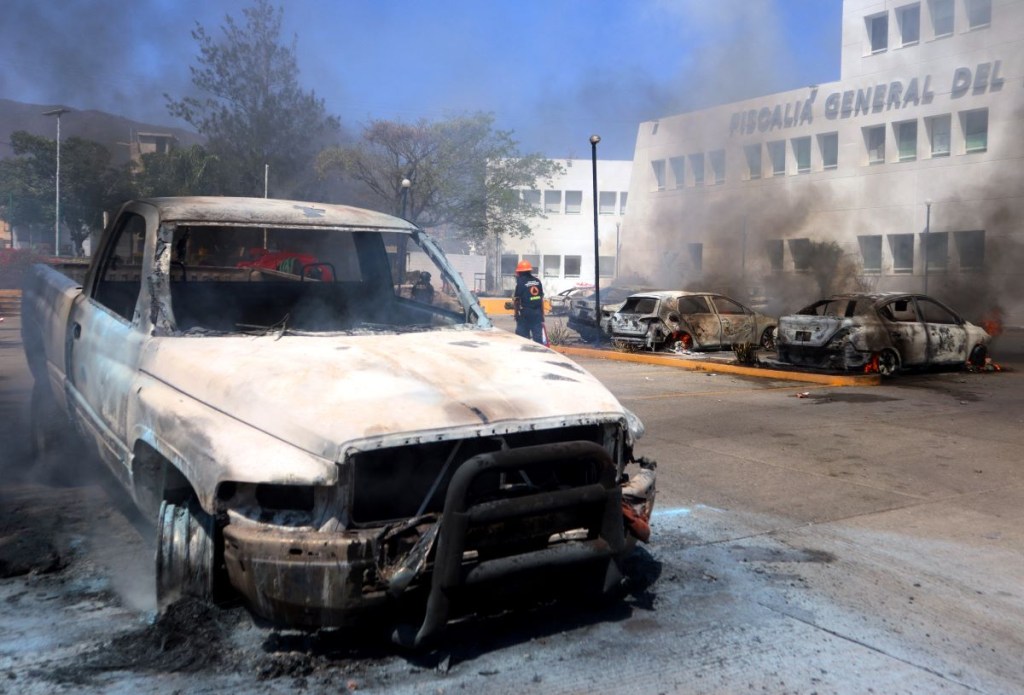 Vehículos incendiados por presuntos estudiantes de la Escuela Rural normal 'Isidro Burgos' de Ayotzinapa se ven fuera de la Oficina de Attonería local en Chilpancingo, Guerrero, México, el 12 de marzo de 2024. (Foto de EDUARDO GUERRERO/AFP vía Getty Images)