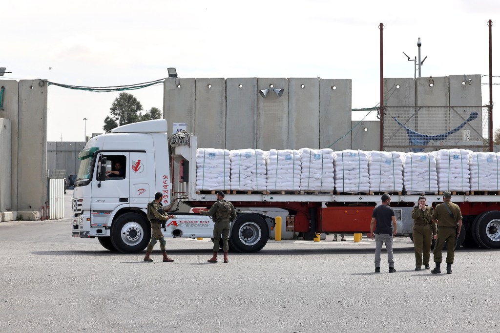 Las fuerzas de seguridad israelíes se encuentran cerca de un camión que transporta ayuda humanitaria destinada a Gaza y esperando ser autorizado en el cruce fronterizo de Kerem Shalom el 14 de marzo. (Jack Guez/AFP/Getty Images)