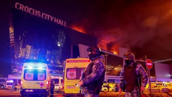 Agentes de seguridad afuera de la sala de conciertos Crocus City Hall en llamas luego del ataque del viernes. (Yulia Morózova/Reuters)