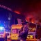Agentes de seguridad afuera de la sala de conciertos Crocus City Hall en llamas luego del ataque del viernes. (Yulia Morózova/Reuters)