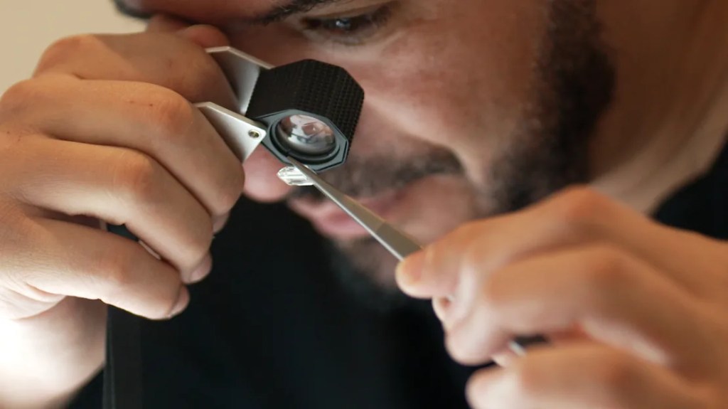 Mohammed Sabeg, co-founder of Dubai-based company 2DOT4, is examining lab-grown diamonds.  (Paul DeWitt/CNN)