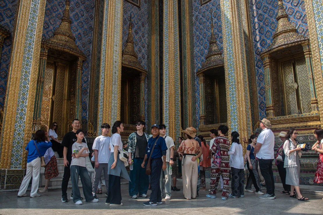Chinese tourists visit the Temple of the Emerald Buddha in Bangkok.  (Credit: Pirapon Boonyakiat/SOPA Images/LightRocket/Getty Images)