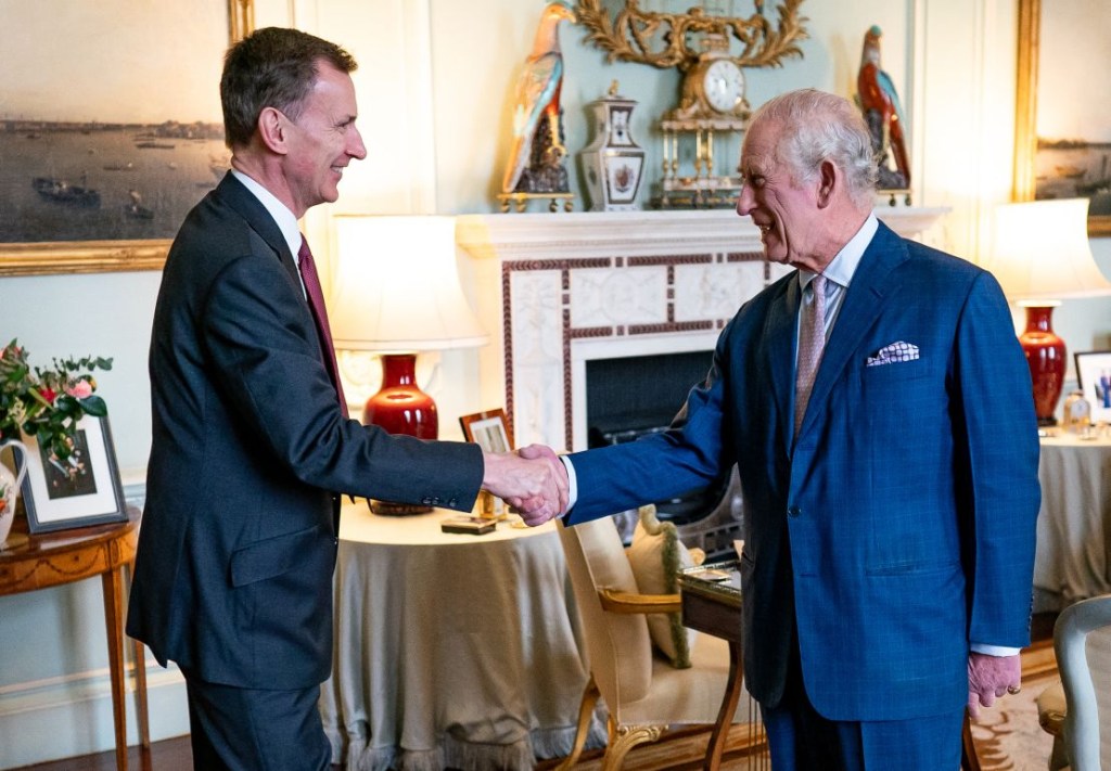 Carlos III saluda al ministro de Hacienda Jeremy Hunt en la sala privada de audiencias del Palacio de Buckingham en Londres el martes. (Crédito: Aaron Chown/AFP/Getty Images)