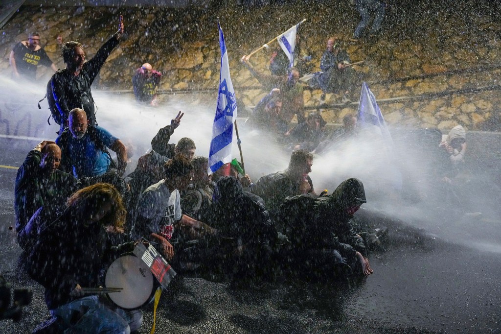 La policía utiliza cañones de agua para dispersar a los manifestantes en Tel Aviv el 9 de marzo. (Ariel Schalit/AP)