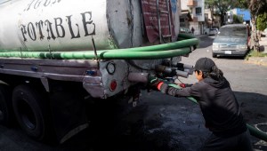 Un trabajador conecta una manguera a un camión cisterna afuera de un complejo de departamentos en el barrio Las Peñas en Iztapalapa el 27 de febrero de 2024 en Ciudad de México, México. (Foto de Toya Sarno Jordan/Getty Images)
