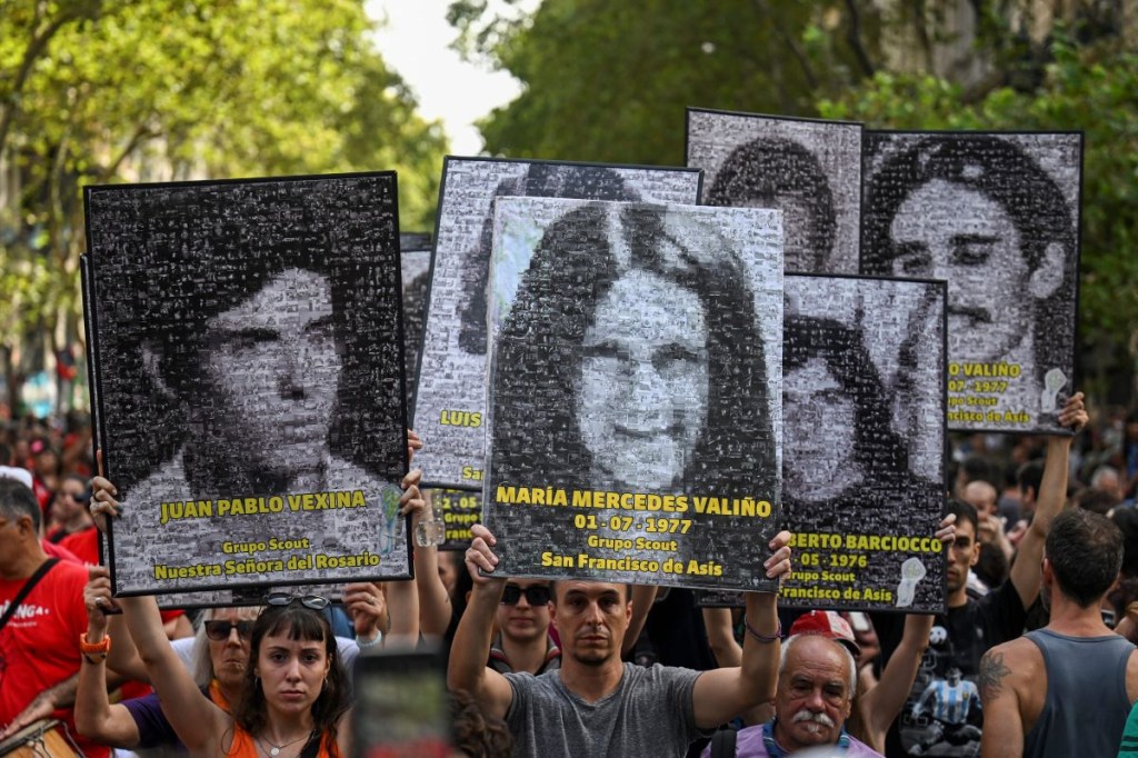 Los manifestantes sostienen retratos de personas desaparecidas durante la dictadura militar (1976-1983) durante una marcha para conmemorar el 47º aniversario del golpe en la Plaza de Mayo de Buenos Aires el 24 de marzo de 2023. (LUIS ROBAYO/AFP via Getty Images)