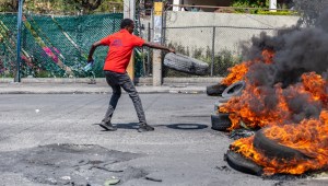 Un hombre prende fuego a un neumático durante una manifestación tras la dimisión del primer ministro haitiano, Ariel Henry. Guérinault (Foto: Louis/Agencia Anadolu/Getty Images).