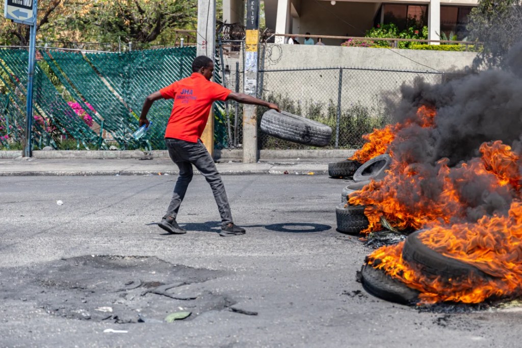 Un hombre prende fuego a un neumático durante una manifestación tras la dimisión del primer ministro haitiano, Ariel Henry. Guérinault (Foto: Louis/Agencia Anadolu/Getty Images).