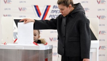 Una mujer con su hijo vota en las elecciones presidenciales de Rusia en Moscú el 16 de marzo de 2024. (Foto de NATALIA KOLESNIKOVA/AFP vía Getty Images)