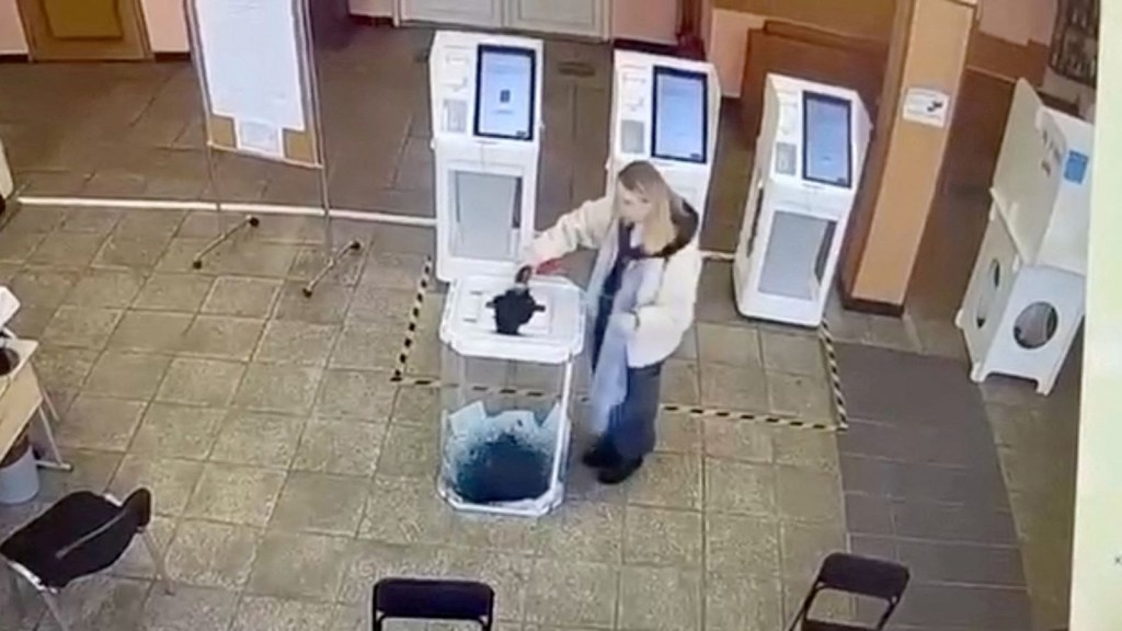 A woman pours green ink into a ballot box to protest the election in Russia.