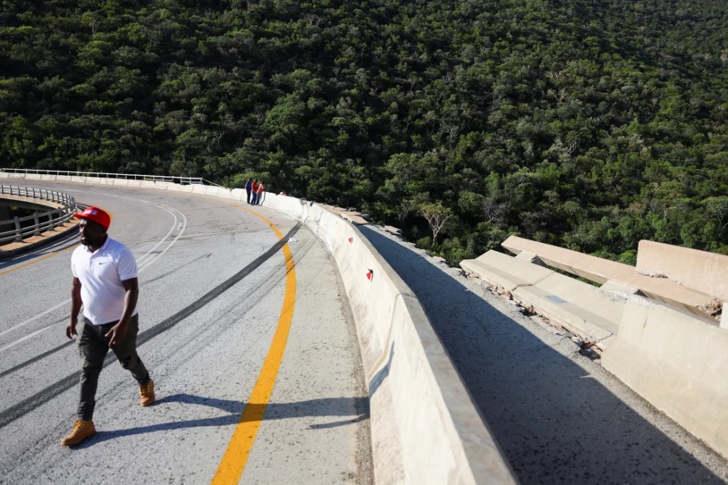 Un hombre pasa por la parte dañada del puente, donde el autobús chocó contra las barreras. (Foto: Siphiwe Sibeko/Reuters).