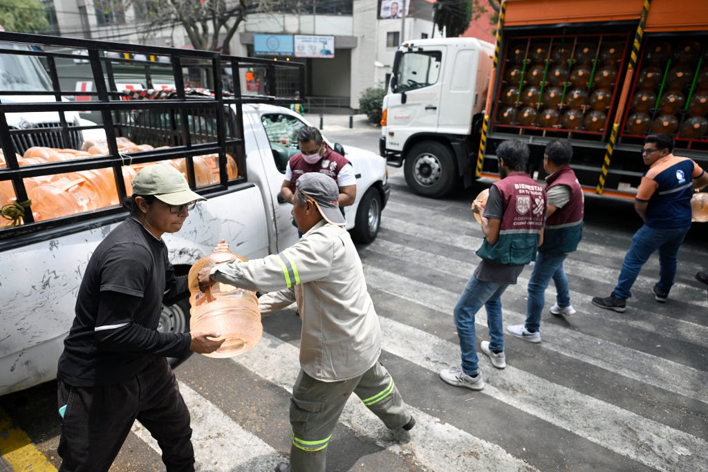 Empleados del gobierno de la Ciudad de México, distribuidores de agua y voluntarios bajan cántaros de agua potable en la colonia Tlacoquemecatl en la Ciudad de México, el 11 de abril de 2024. (Foto: de ALFREDO ESTRELLA/AFP vía Getty Images).