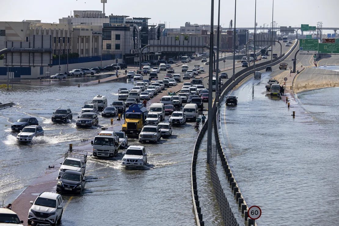 Many vehicles are running in flood waters caused by heavy rains in Dubai on Thursday.  (Credit: Christopher Pike/AP)