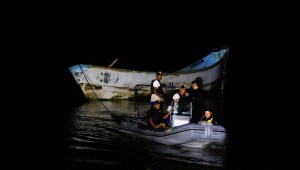 Agentes de policía y rescatistas remolcan un barco con cuerpos en descomposición encontrados por pescadores cerca del puerto de Vila do Castelo en Bragança, estado de Pará, Brasil, el 14 de abril. (Oswaldo Forte/Reuters)