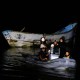 Agentes de policía y rescatistas remolcan un barco con cuerpos en descomposición encontrados por pescadores cerca del puerto de Vila do Castelo en Bragança, estado de Pará, Brasil, el 14 de abril. (Oswaldo Forte/Reuters)