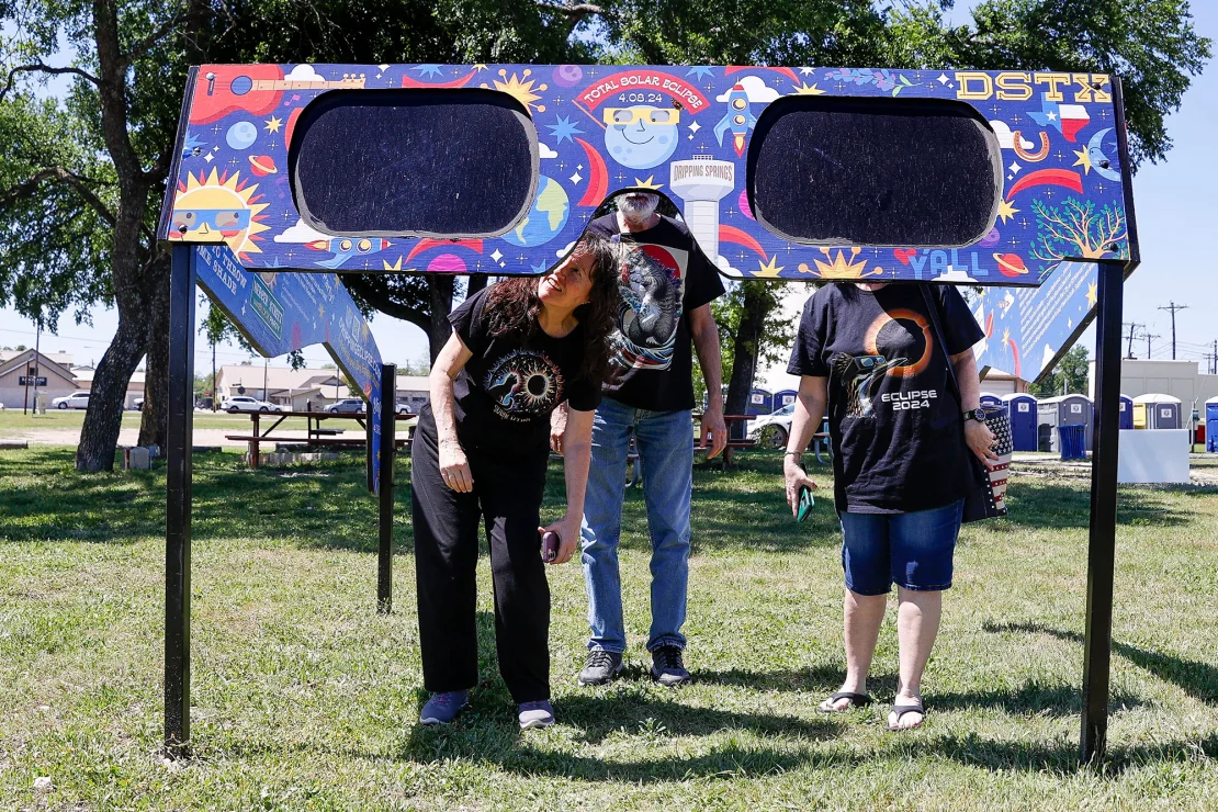 A family looks at the giant solar eclipse mirrors at Veterans Memorial Park in Dripping Springs, Texas on April 4, 2024.  Adam Davis/EPA-EFE/Shutterstock