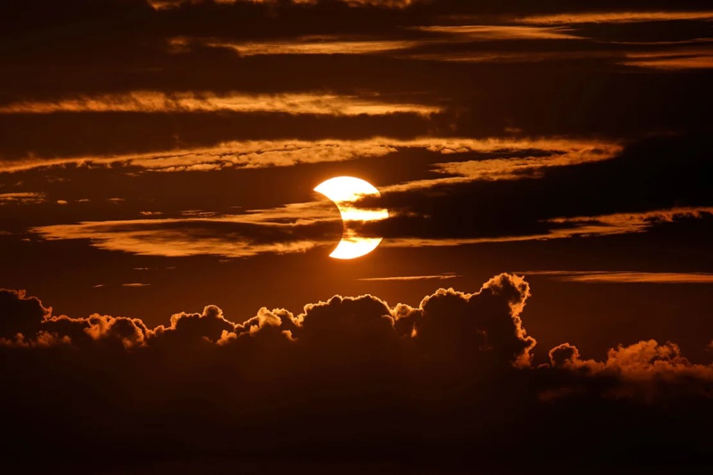 Se ven nubes de alto nivel en la parte superior de la imagen mientras se desarrolla un eclipse solar parcial detrás de las nubes, el jueves 10 de junio de 2021, en Arbutus, Maryland. Julio Cortez/AP