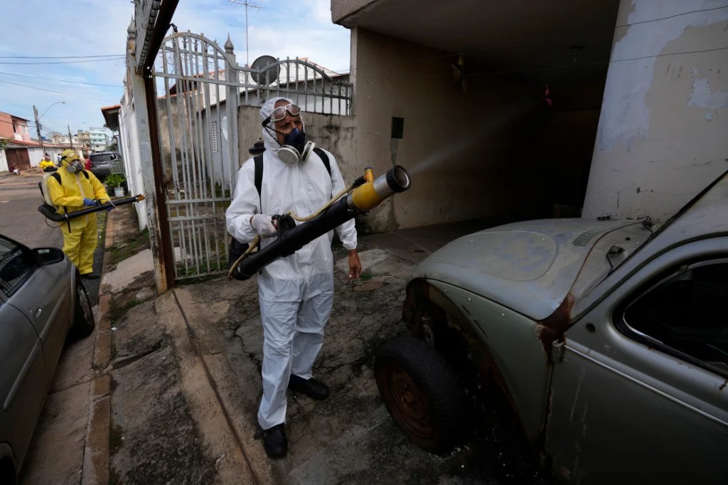 Trabajadores de salud pública rocían insecticida durante una campaña de fumigación en el barrio Ceilandia de Brasilia, Brasil, el viernes 16 de febrero de 2024. (Eraldo Peres/AP)