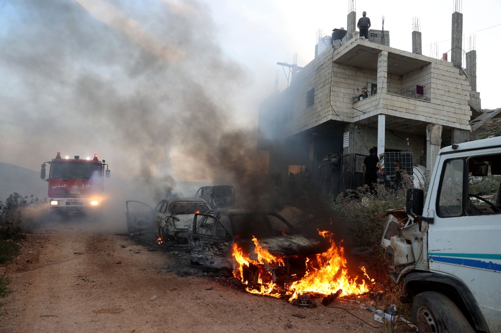 Una vista de casas dañadas y vehículos en llamas después de una incursión de colonos israelíes en una ciudad cerca de Ramallah, Ribera Occidental el 12 de abril. (Issam Rimawi/Anadolu/Getty Images)