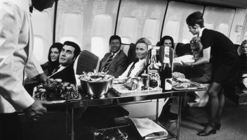 Auxiliares de vuelo sirven bebidas a los pasajeros de primera clase a bordo de un Boeing 747 en una imagen de mediados del siglo XX. (Crédito: Fox Photos/Hulton Archive/Getty Images)