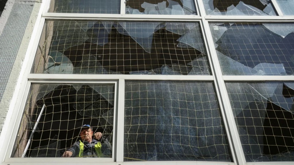 Un trabajador retira fragmentos de vidrio de una ventana rota, en una escuela dañada por un ataque con misiles rusos en Járkiv, Ucrania, el 8 de mayo de 2024. (Foto: Sofiia Gatilova/Reuters)
