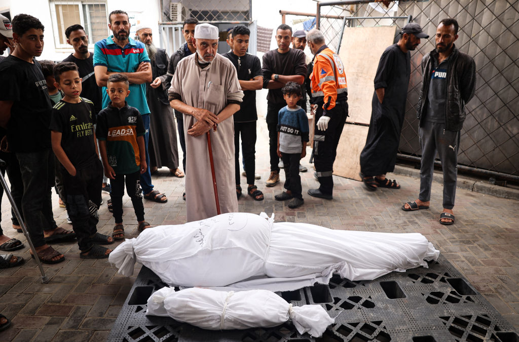 Los dolientes se encuentran cerca de los cadáveres de un adulto y un niño muertos en un bombardeo israelí nocturno, frente a la morgue de un hospital en Rafah, en el sur de Gaza, el 27 de abril de 2024. (Foto: AFP vía Getty Images).