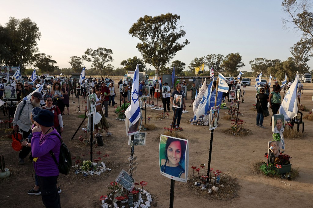 Los visitantes presentan sus respetos en un monumento con retratos de personas tomadas como rehenes o asesinadas en el ataque de Hamas en el sur de Israel el 9 de mayo de 2024. (Ahmad Gharabli/AFP/Getty Images)