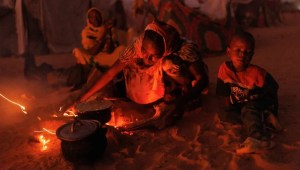 Refugiados recién llegados de Sudán cocinan comida en fogatas afuera de sus refugios improvisados, el 24 de abril de 2024 cerca de Adré, Chad. (Dan Kitwood/Getty Images)