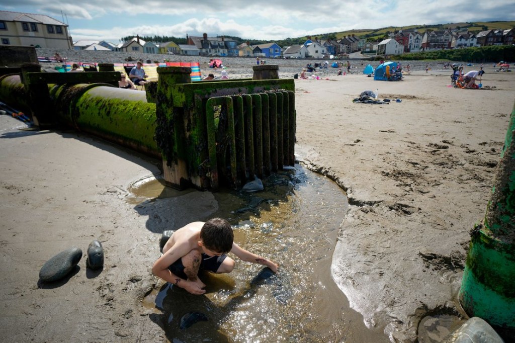 Los desbordamientos por tormentas son habituales en las playas del Reino Unido. En la imagen, un niño juega con el vertido de un desbordamiento en la playa de Borth, Gales. (Crédito: Christopher Furlong/Getty Images)