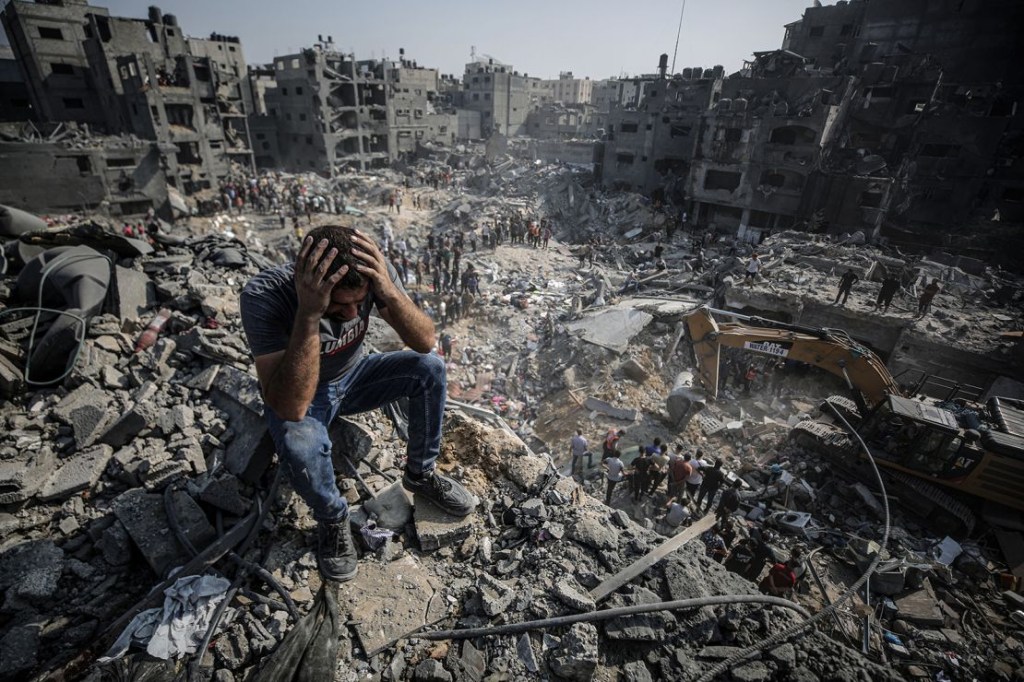 Un hombre, sentado sobre escombros, reacciona mientras los palestinos llevan a cabo una operación de búsqueda y rescate tras un segundo bombardeo del ejército israelí en el campo de refugiados de Jabalia, en Gaza, el 1 de noviembre de 2023. (Crédito: Ali Jadallah/Anadolu/Getty Images)