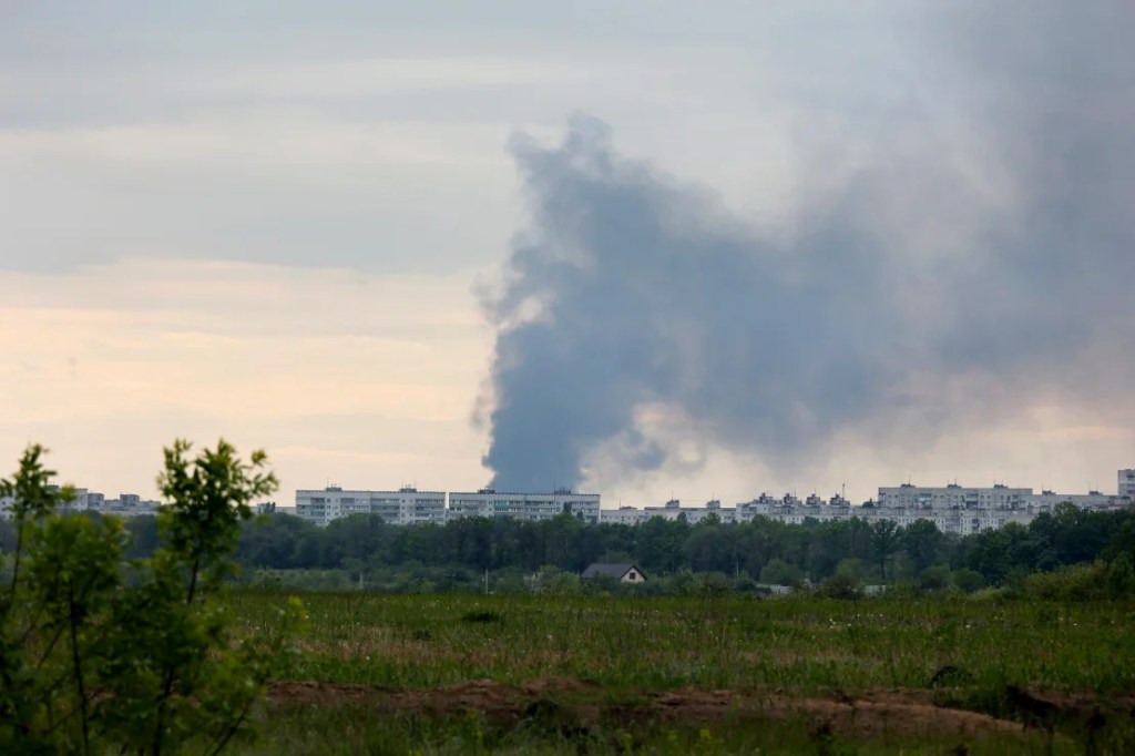 Una columna de humo se eleva desde detrás de bloques de apartamentos tras el bombardeo de las tropas rusas en Járkiv el viernes. (Ukrinform/NurPhoto/Getty Images)