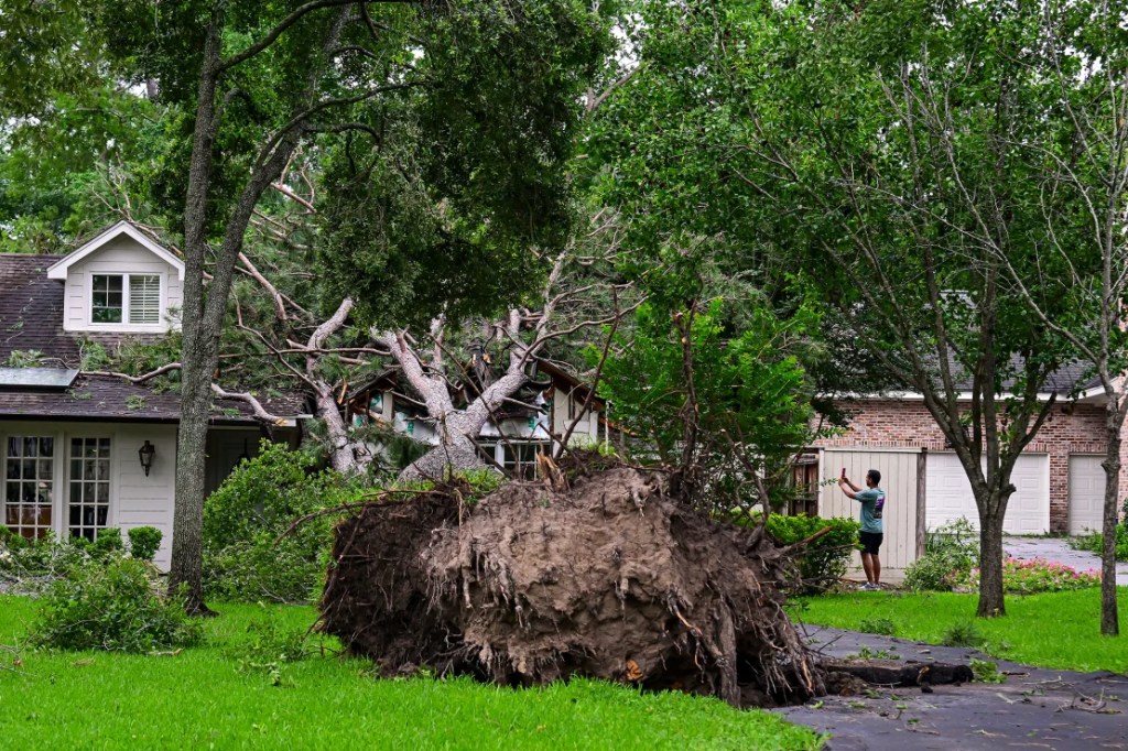Un árbol caído daña una casa después de que fuertes vientos y lluvias azotaran la región en Houston, Texas, el viernes. (Logan Riely/Getty Images)