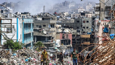 La gente pasa junto a un montón de basura y edificios destruidos en Jabalya, Gaza, el 14 de mayo. (Foto: AFP/Getty Images).