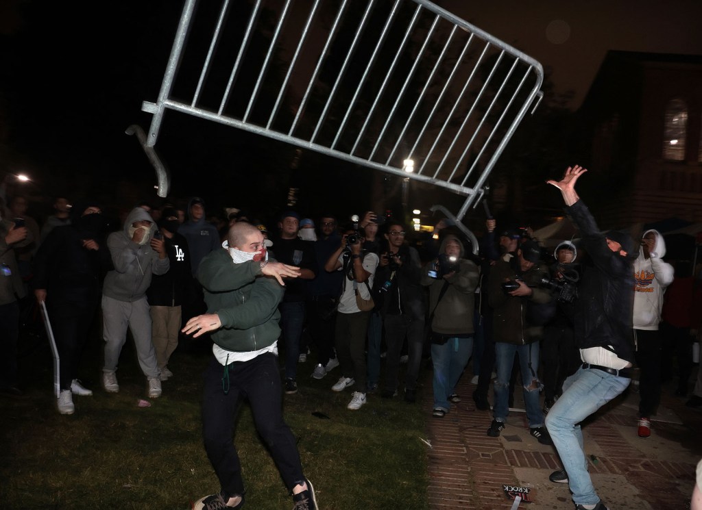 Manifestantes propalestinos y partidarios pro-Israel se enfrentan en un campamento en UCLA el miércoles por la mañana temprano. (Wally Skalij/Los Angeles Times/Getty Images)