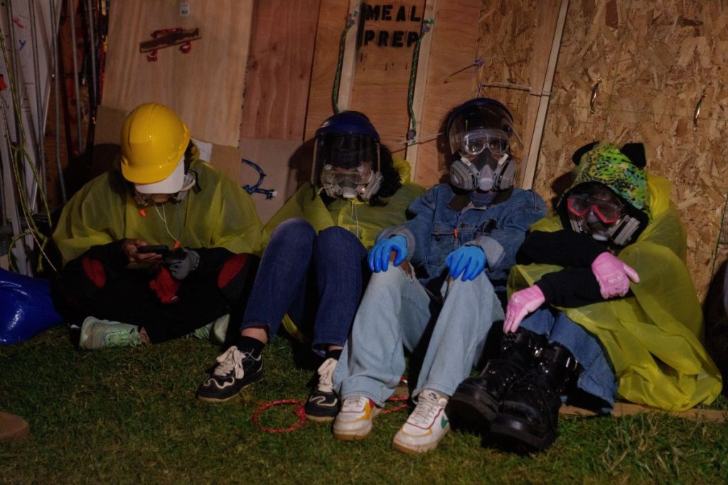 Manifestantes propalestinos se sientan en el suelo contra un muro improvisado en un campamento en UCLA el 2 de mayo de 2024 en Los Ángeles, California. (Foto de Eric Thayer/Getty Images)