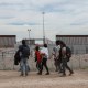 Migrantes de diferentes nacionalidades que buscan asilo en Estados Unidos llegan a la línea fronteriza entre México y Estados Unidos en Ciudad Juárez, estado de Chihuahua, México, el 24 de abril de 2024. (Foto de HERIKA MARTINEZ/AFP vía Getty Images)