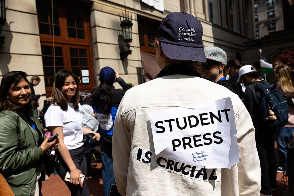Un estudiante de periodismo de Columbia muestra su cartel mientras cubre los eventos en Hamilton Hall en la Universidad de Columbia el martes 30 de abril. (Michael M. Santiago/Getty Images)