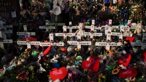 Se amontonan flores alrededor de cruces con los nombres de las víctimas que murieron en un tiroteo en una escuela mientras la gente visita un monumento en la Escuela Primaria Robb para presentar sus respetos el 31 de mayo de 2022, en Uvalde, Texas. (Jae C. Hong/AP)