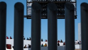 Solicitantes de asilo caminan hacia su cita para la entrevista de asilo con las autoridades estadounidenses en el puerto fronterizo de El Chaparral en Tijuana, estado de Baja California, México, el 18 de mayo de 2024. (Crédito: GUILLERMO ARIAS/AFP vía Getty Images)