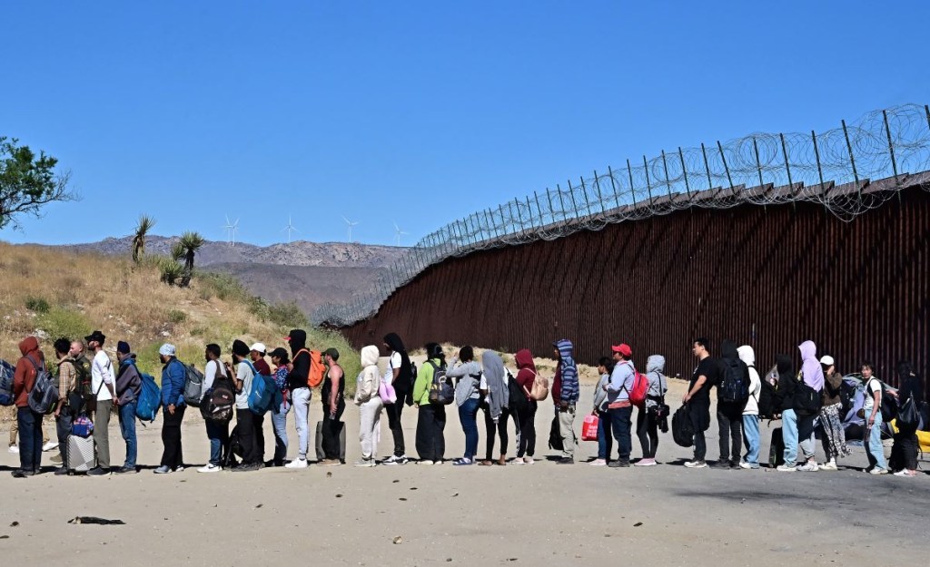 Migrantes esperan en fila con la esperanza de ser procesados ​​por los agentes de Aduanas y Patrulla Fronteriza de Estados Unidos el 5 de junio de 2024. (Foto de FREDERIC J. BROWN/AFP vía Getty Images)