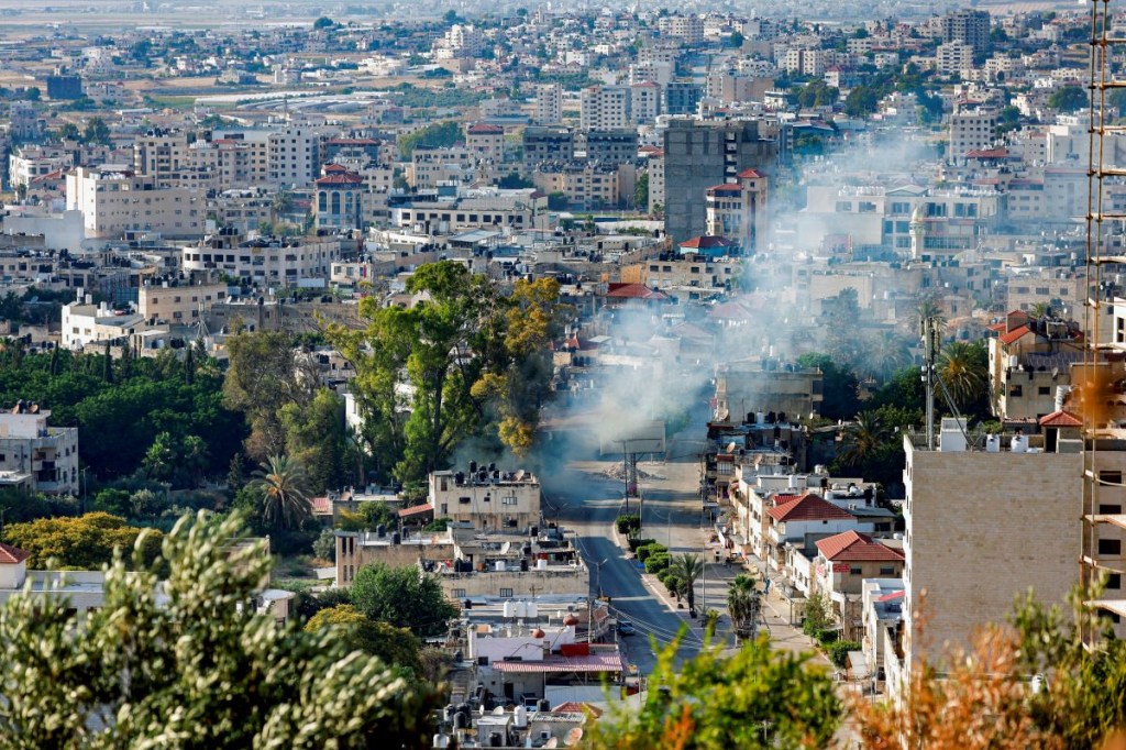 Esta fotografía tomada desde una posición elevada muestra una nube de humo que se eleva durante una redada del ejército israelí en Yenín, en la ocupada Ribera Occidental, el 6 de junio de 2024. (Foto de JAAFAR ASHTIYEH/AFP vía Getty Images)