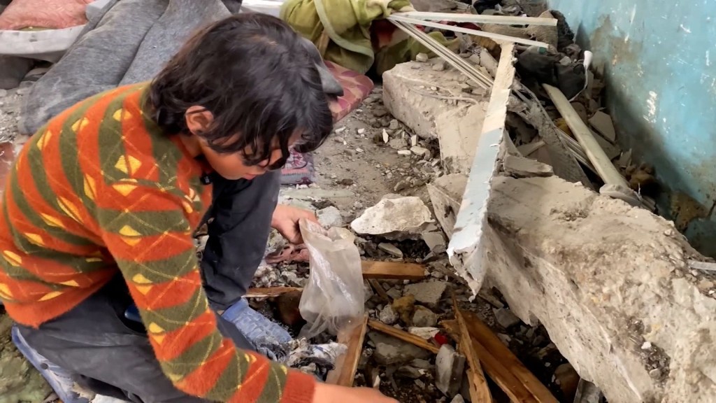 NiÃ±o reÃºne pedazos de los restos de su hermano despuÃ©s de que una bomba israelÃ­ estallara en una escuela en Gaza