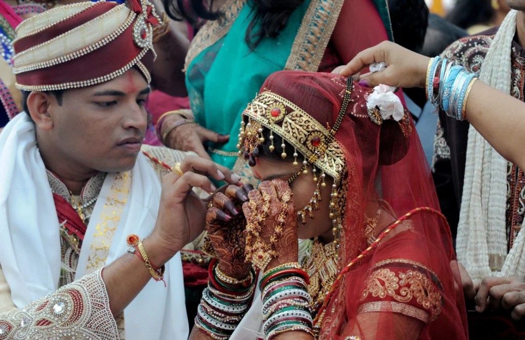 Un novio hindú jainista ayuda a su novia como el "Mangal Sutra", el "hilo sagrado y auspicioso". (SAM PANTHAKY/AFP/AFP/Getty Images)