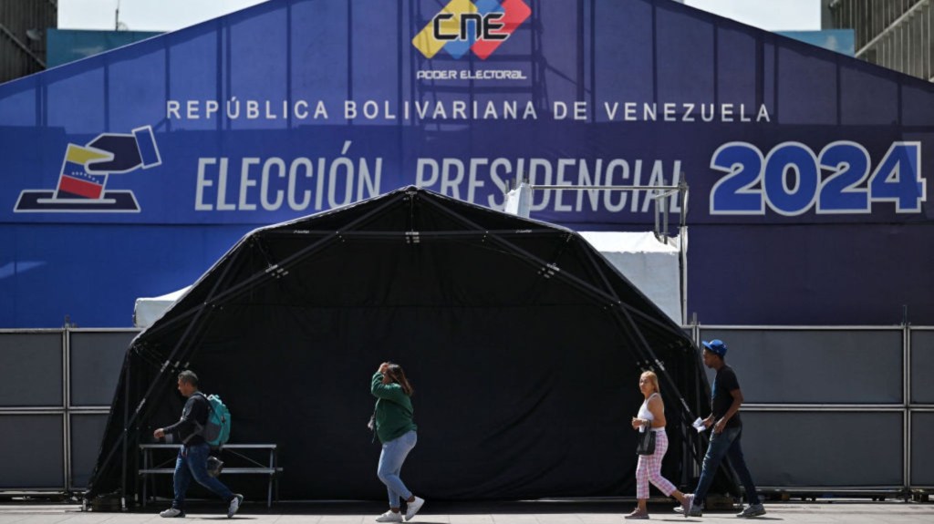 Personas caminan frente al centro de prensa del Consejo Nacional Electoral (CNE) en Caracas el 27 de julio de 2024. (Foto: JUAN BARRETO/AFP vía Getty Images)
